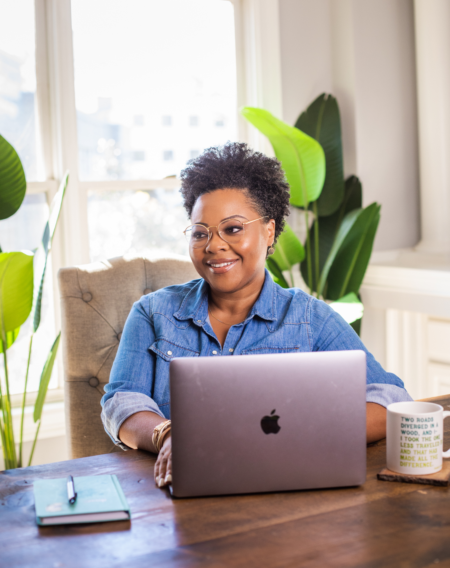 Portrait of Zakiya Akerele seated at a wooden table.